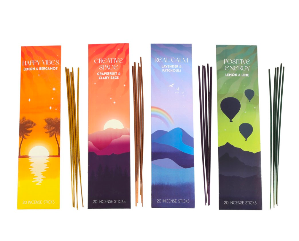 Four boxed incense sticks with matching incense rods displayed side by side on a white background. The boxes feature colorful illustrated panels with text including Happy Vibe's, Creative Space, Real Calm, and Positive Energy.