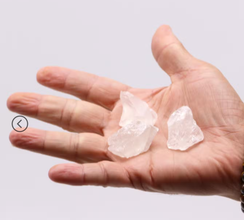 Individual raw Clear Quartz crystals shown in a hand, displaying natural translucent white colouring