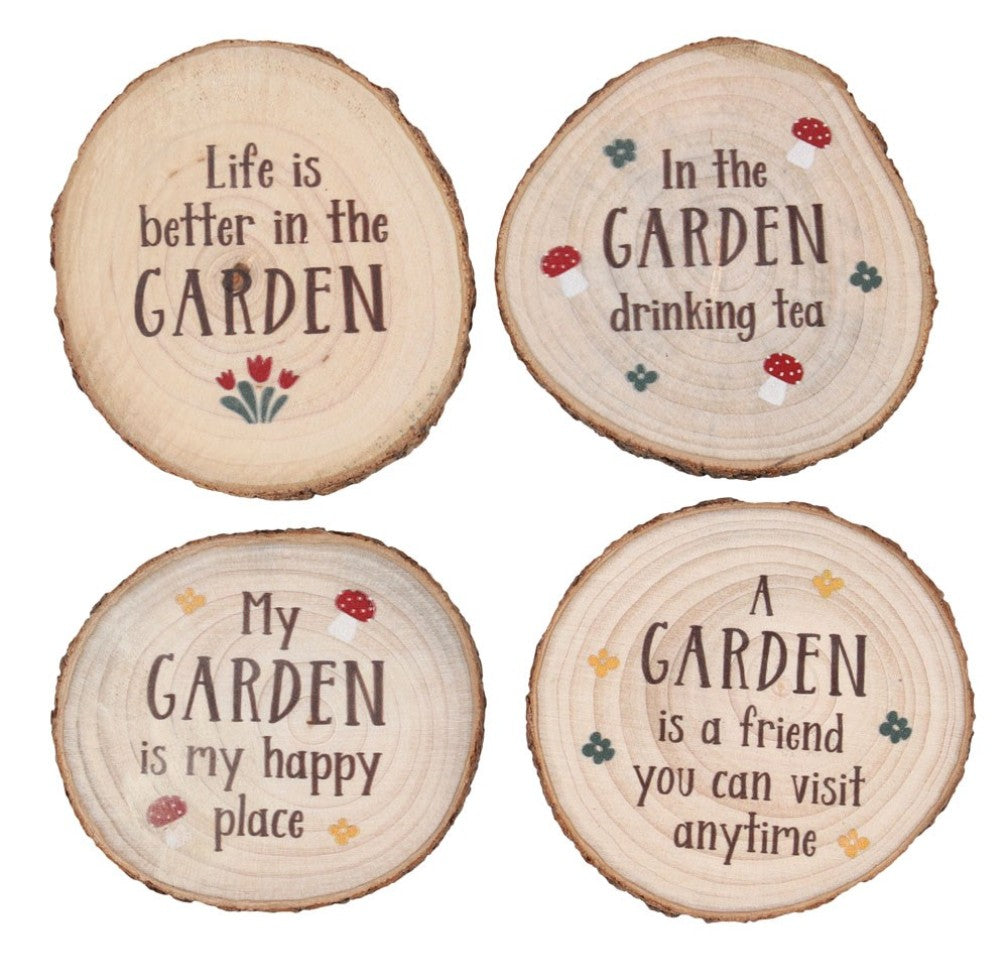 Four round wooden slice coasters or signs with rustic bark edges, each printed with a garden-themed quote in dark brown lettering and small colorful floral accents, shown on a white background.