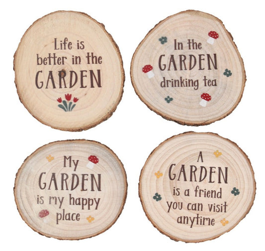 Four round wooden slice coasters or signs with rustic bark edges, each printed with a garden-themed quote in dark brown lettering and small colorful floral accents, shown on a white background.