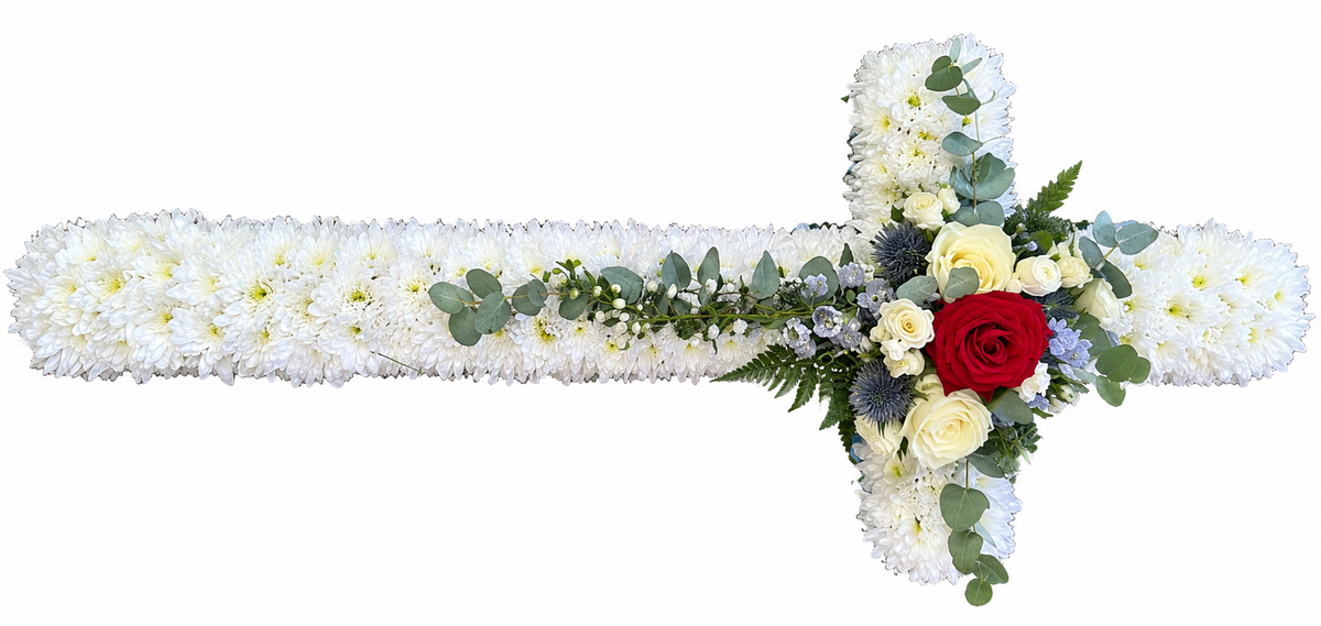 A floral cross-shaped arrangement made of white chrysanthemums with green foliage and a small red rose at the center, shown on a plain white background.