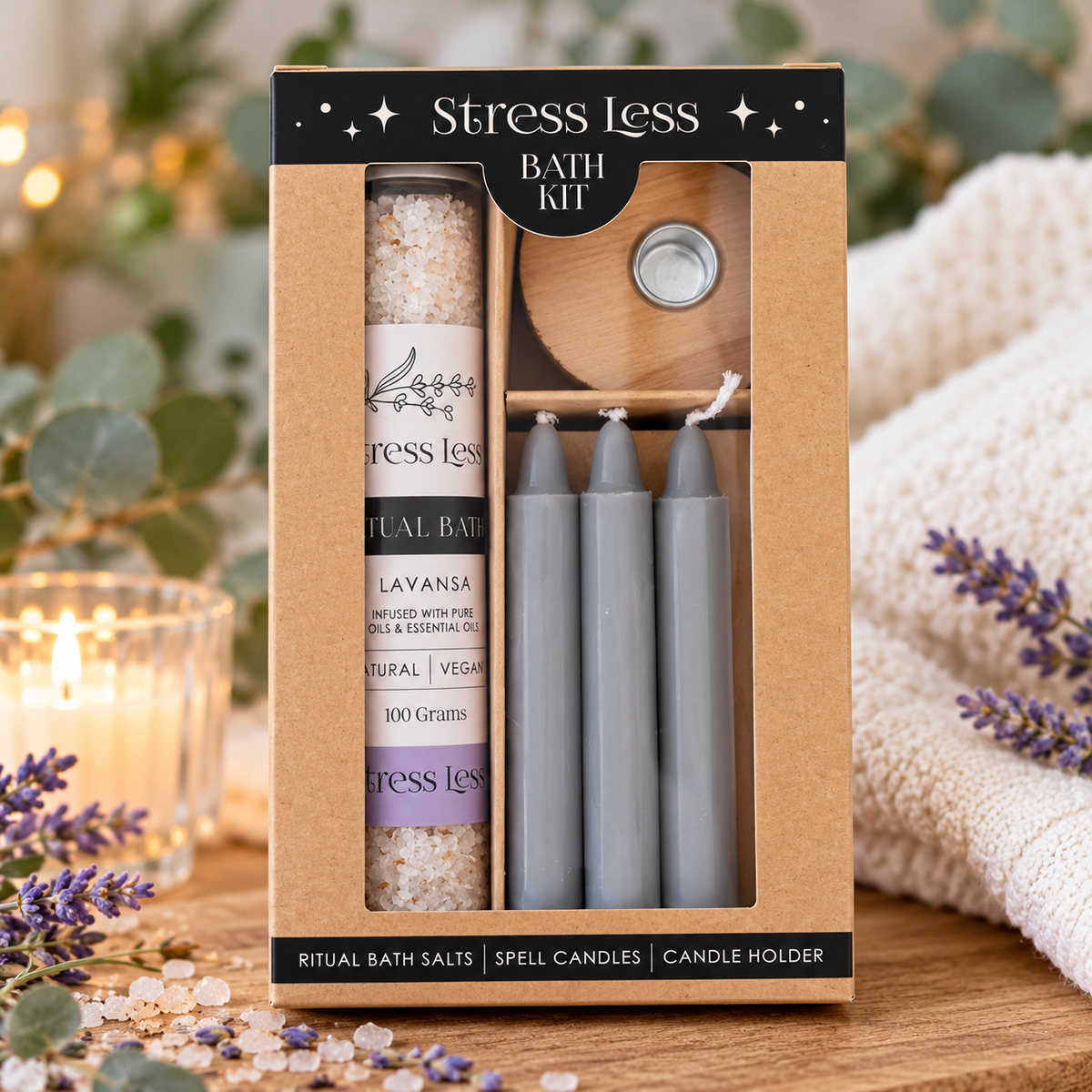 A Stress Less Bath Kit in a kraft paper box, containing lavender bath salts, gray spell candles, and a wooden candle holder, styled on a wooden table with a lit candle and lavender sprigs.