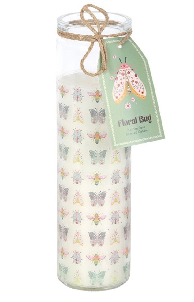 A tall glass jar candle filled with white wax and decorated with a repeating pattern of colorful butterflies and bees. The jar is tied with a twine bow and has a green paper tag attached that reads 'Floral Bug'.